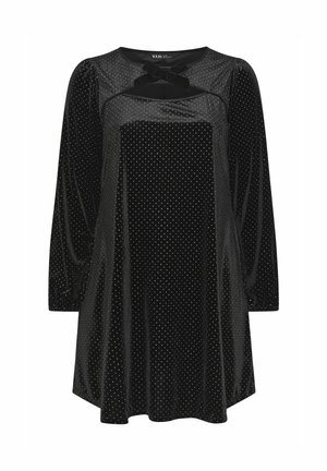 Abito di velluto nero con maniche lunghe, motivo a pois, scollatura rotonda, dettaglio a fiocco sul petto, silhouette fluida e polsini arricciati.