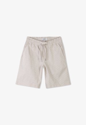 Shorts de couleur beige clair avec une taille élastique et un cordon de serrage. Motif géométrique blanc remarquable sur le tissu. Texture lisse.