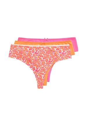 Plus-Size-Frau trägt rosa und orange Leopardenmuster-BH und passende Höschen, richtet den Bund vor weißem Hintergrund.