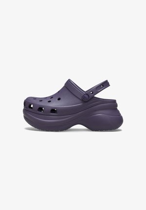 Purple clogs with a textured surface, open vented design, back strap, and a chunky sole for comfort and support.