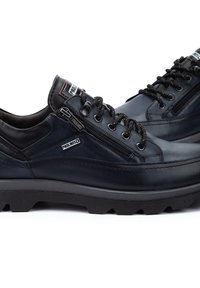 Zapatos de cuero navy con un acabado texturizado, que cuentan con cierre de cremallera, diseño de cordones, suela de goma gruesa y detalles de marca en el lateral.