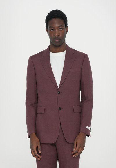 Bordeauxfarbener Anzugjacke mit zwei Knöpfen, mit Revers und seitlichen Taschen. Getragen über einem weißen Hemd mit subtiler Textur und taillierter Passform.