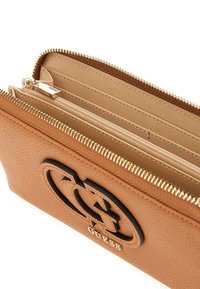 Brown textured leather wallet with a black logo and gold hardware. Features multiple compartments and a zipper closure for secure storage.