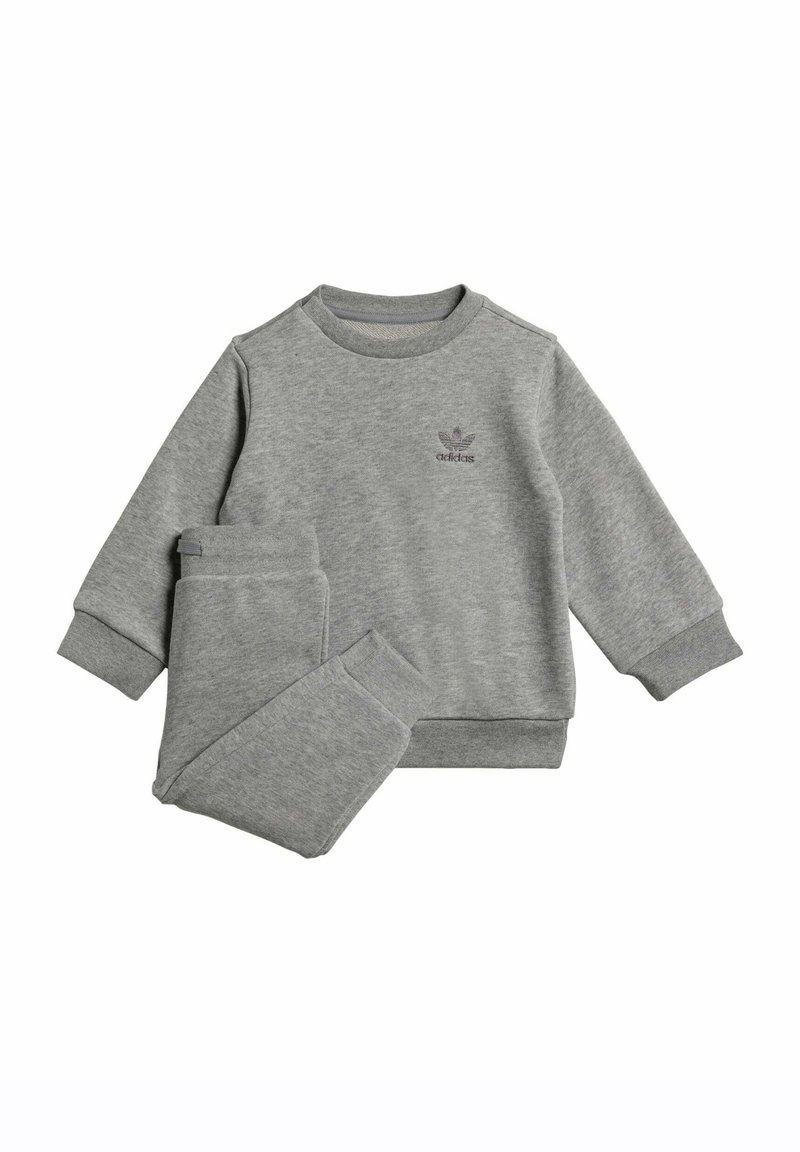 Completo felpa e pantaloni grigi, realizzato in tessuto morbido. Presenta polsini e scollo a costine, con un piccolo logo Adidas sul petto.
