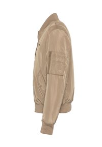Giacca bomber beige con una texture liscia e lucida, dotata di colletto e polsini a coste, chiusura con zip e tasca a toppa sul braccio.