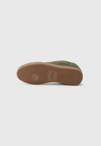 Single olive green suede sneaker lying on its side showing a brown rubber sole with FILA logo and patterned tread.