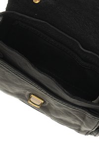 Interno di una borsa nera in pelle con texture morbida, caratterizzata da un clasp in metallo dorato e bordi lisci, non cuciti.