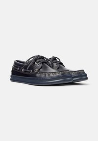 Dunkelblaue Lederschuhe mit Schnürsenkeln und kontrastierenden Nähten, mit Gummisohle und lässigem Design, auf einem hellgrauen Hintergrund platziert.