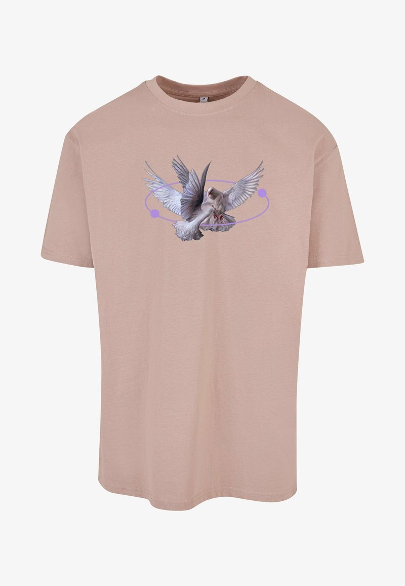 Šviesiai rožinė medvilninė marškinė su piešiniu, vaizduojančiu paukštį su išskleistais sparnais, papuoštu purpuriniu apvališku dizainu aplink jį.