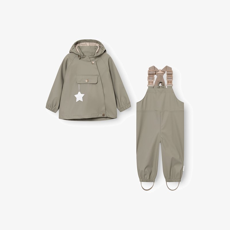Giacca impermeabile verde oliva per bambini con cappuccio e ciondolo a forma di stella, abbinata a salopette impermeabili coordinate con spalline regolabili e passanti per i piedi.