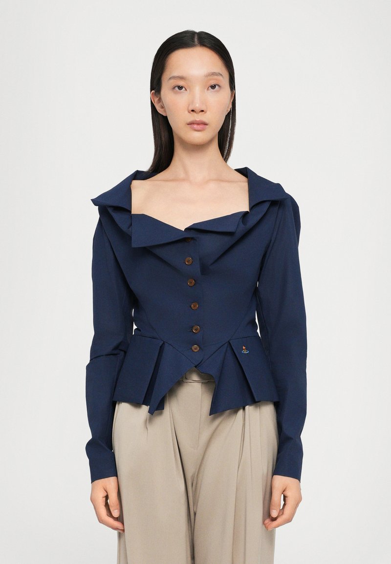 Navy blue tailored jacket with a wide, ruffled collar, eight buttons, and pleated hem. Made of structured fabric; features slight sheen.
