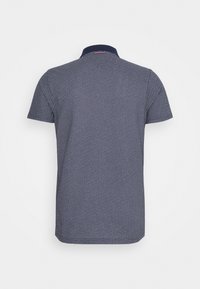 Polo à manches courtes de couleur bleu marine avec un motif texturé et un col contrasté. Il possède un ourlet droit et un détail de logo discret au dos.