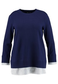 Marineblauer Pullover mit langen Ärmeln und gerippten Bündchen, übereinander getragen mit einem weiß und marineblau gestreiften Saum. Weicher Stoff und lockere Passform.