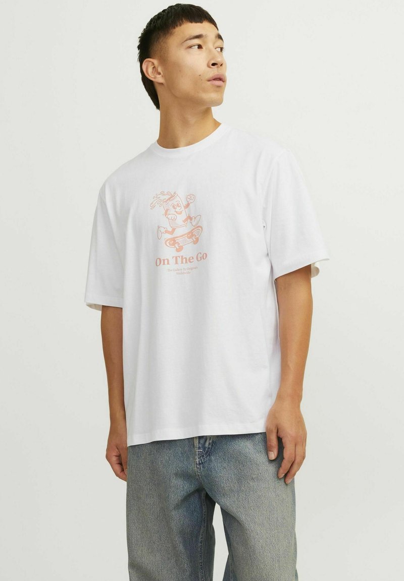 Camiseta de algodón blanca con un gráfico divertido de un personaje en patineta en rosa claro, con mangas cortas y un corte relajado.