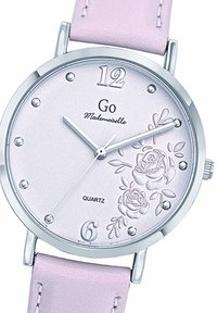 Montre à quartz avec un boîtier en argent, un cadran rose clair featuring des roses en relief, et un bracelet en cuir rose doux. Index à 12 et 6.