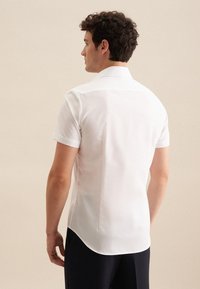 Witte blouse met korte mouwen, een klassieke kraag, gladde stof en een gebogen zoom. Kenmerkt zich door een schoon, minimalistisch ontwerp zonder zichtbare patronen.
