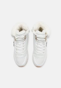 Sneaker alte bianche con colletto in pelliccia morbida, caratterizzate da dettagli per perforazioni, lacci bianchi e accenti metallici sugli occhielli.