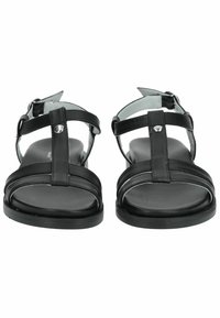 Černé sandály s t-řemínkovým designem a nastavitelnými kotníkovými řemínky, vyrobené z hladké kožené hmoty, s plochou podrážkou a minimálními detaily.