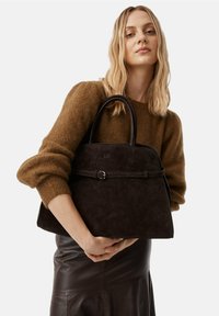 Borsa a tracolla in pelle scamosciata marrone scuro dal design strutturato, con una fascia centrale a fibbia e due manici arrotondati. Texture liscia e forma elegante.