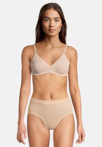 Soutien-gorge beige con spalline regolabili e coppe morbide, abbinato a slip a vita alta coordinati. Texture liscia, design senza cuciture.