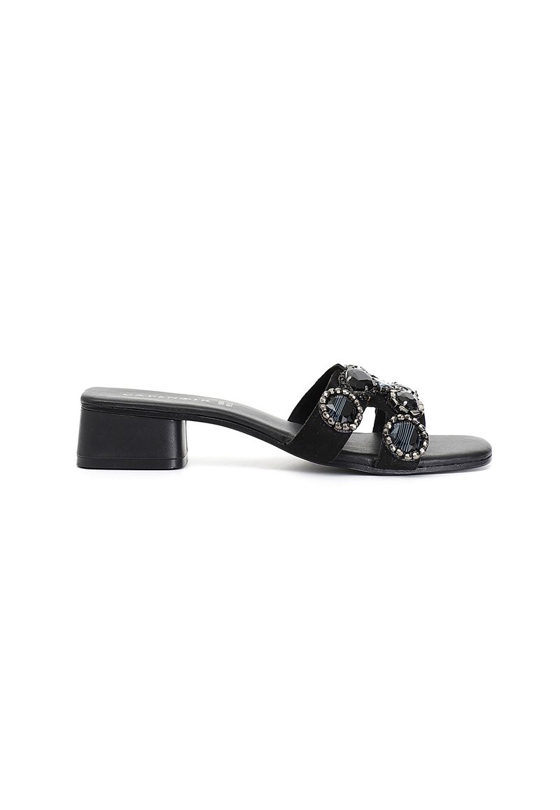Sandal in suede nero con tacco basso a blocco, caratterizzata da doppi cinturini decorati con accenti di gemme circolari. Texture liscia e design minimalista.