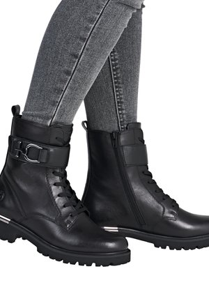 Bottines noires en cuir avec un devant à lacets, zip sur le côté et sangle ajustable. Elles sont dotées d'une semelle texturée et d'un accent en argent au niveau du talon.