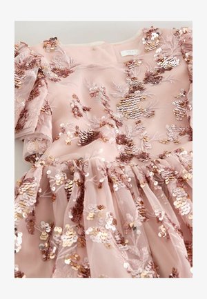 Ružové šaty s kvetinovou výšivkou z flitrov, s volánovými rukávmi a rozšírenou sukňou. Vyrobené z tylu a podšité jemnou látkou.