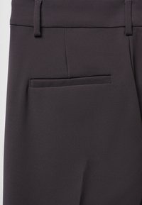 Dunkelgraue maßgeschneiderte Hose mit glatter Textur, schlanker Passform und einer einzelnen Gesäßtasche mit gefaltetem Eingang.