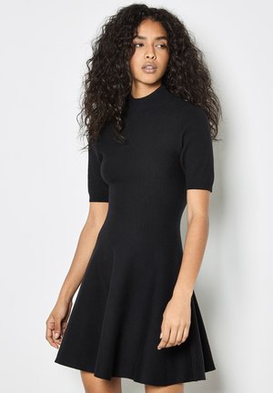 Vestido negro de manga corta con un corsé ajustado y falda acampanada. Hecho de un material de punto, con un escote alto y textura suave.
