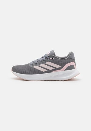 Chaussure de course légère grise et rose avec tige en mesh, semelle blanche amortie et fermeture à lacets, vue de côté sur fond blanc.