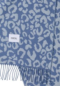 Écharpe bleue à motif léopard avec bords à franges, fabriquée en tissu doux. L'étiquette porte l'inscription "CECIL" en texte noir sur fond blanc.