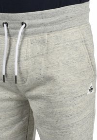 Helle grau Sweatpants aus strukturiertem Stoff; mit einem elastischen Bund und Kordeln sowie einem kleinen Logopatch.