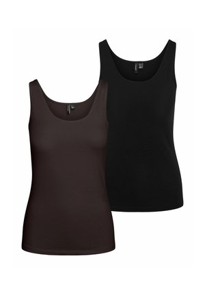 Femme debout portant un haut noir sans manches, un pantalon noir à jambes larges et des ballerines noires sur un fond clair uni.
