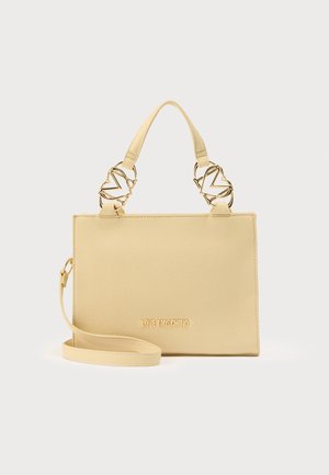 Dzeltens mākslīgās ādas rokassoma ar strukturētu formu, zeltaini krāsas metāla detaļām, augšējiem rokturiem un noņemamu plecu siksnu. Rotāta ar reljefa logotipu.