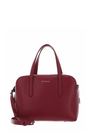 Sac à main en cuir bordeaux avec deux poignées, bandoulière amovible et petit logo de marque argenté "COCCINELLE" sur le devant.