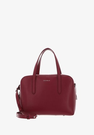 Bordeauxrote Lederhandtasche mit zwei Griffen, abnehmbarem Schulterriemen und kleinem silbernem Markenlogo "COCCINELLE" vorne.