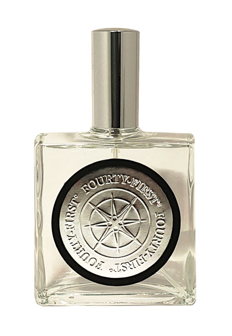 Duidelijke glazen parfumfles met een zilveren dop. Heeft een ronde zwarte en zilveren label met een reliëf van een kompasontwerp en tekst.