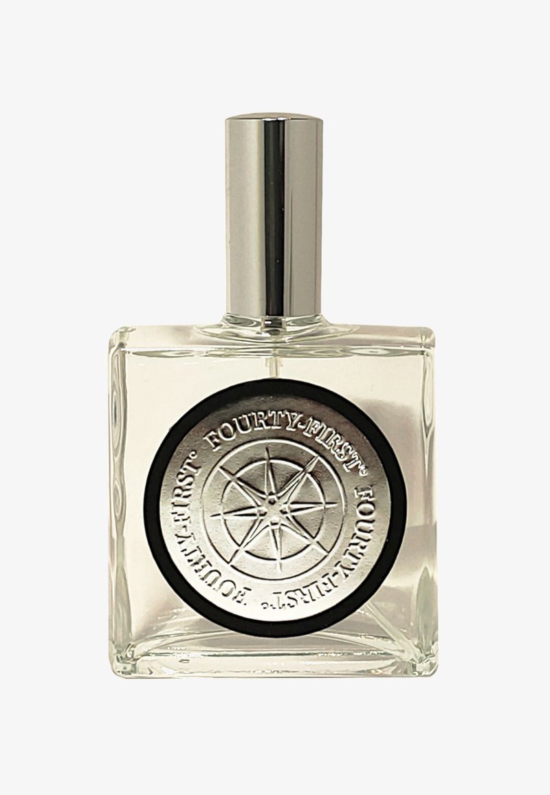 Duidelijke glazen parfumfles met een zilveren dop. Heeft een ronde zwarte en zilveren label met een reliëf van een kompasontwerp en tekst.