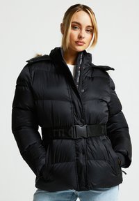 Svart dunjakke med belte i midjen, teksturert overflate, trykknapper og avtakbar hette med falsk pelskant.