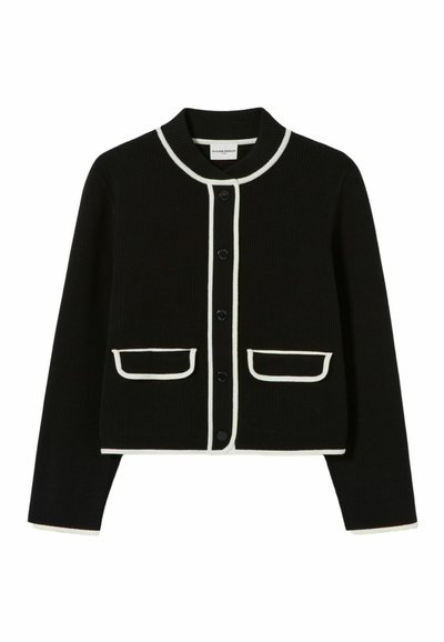 Cardigan nero a coste con colletto rotondo, bordi bianchi, chiusura con bottoni e due tasche frontali con bordi a contrasto.