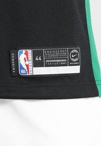 Étiquette de maillot de basket-ball noir NBA Authentic taille 44, logo Nike et texte "ENGINEERED TO THE EXACT SPECIFICATIONS OF CHAMPIONSHIP ATHLETES".