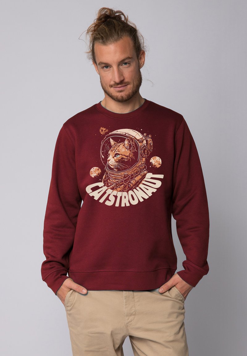 Bordeaux kleurige sweatshirt met lange mouwen bevat een afbeelding van een kat in een astronautenhelm en het woord "CATSTRONAUT" in crème, van een katoenmix.