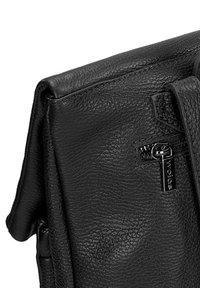 Černá kožená taška s texturovaným povrchem, vrchním klopou a zipovou kapsou s kovovými detaily. Kompaktní design s čistými liniemi.