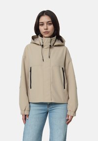 Beige lättviktsjacka med huva, som har elastiska ärmslut, dragkedje-fickor och en mjuk yta, mot en helt vit bakgrund.