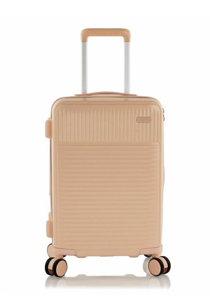 Hard-shell suitcase in pastel pink with ribbed texture, retractable handle, and four multi-directional wheels for easy mobility.