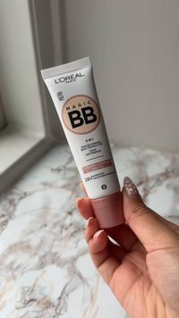 L'Oréal Paris Magic BB cream-tub, vit med rosa detaljer, har fet svart text. Designen anger "5 i 1" och innehåller vitaminerna B5 och E.