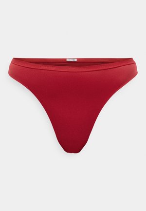 Rode stringonderbroek met een naadloos ontwerp en een zachte textuur. Bevat een Calvin Klein-logo op de elastische tailleband.