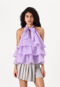 Lavendel chiffon haltertop med lagdelte volanger, med knytehals og nøkkelhulldetalj, kombinert med en plissert grå skjørt.