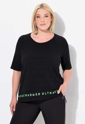 T-shirt noir à manches courtes avec un col rond et un texte graphique vert "ULTRACHARGED" au bas. Tissu lisse avec une coupe relax.