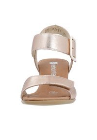 Sandalias planas metálicas en oro rosa con parte superior de cuero suave, una correa con hebilla y diseño recortado sobre una suela beige. Talla 37.
